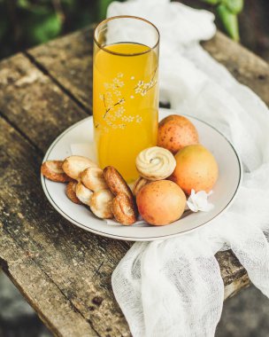 Kurabiye ve olgun meyveli taze kayısı suyu.