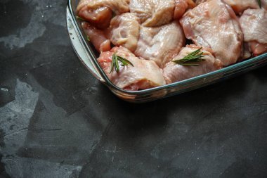 Siyah arka planda baharatlı ve otlu çiğ tavuk. yakın çekim görünümü.