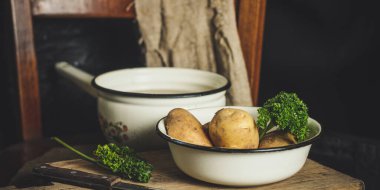 Köy arka planında olgun patatesleri yakın.