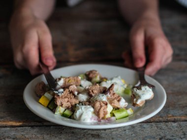 Kadın eli bıçaklı, siyah tabağı çatallı ve kaşıklı.
