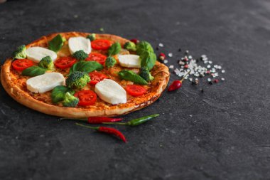 Siyah arka planda mozzarella, fesleğen ve sebzeli pizza. Yakın çekim görüntüsü. Boşluğu kopyala