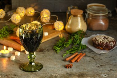 Masada bir kadeh kırmızı şarap ve noel süsü.