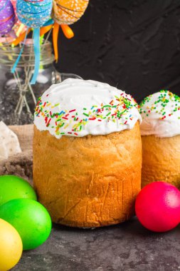 Paskalya pastalarının ve renkli yumurtaların koyu arkaplanda yakın plan görüntüsü.