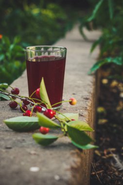 Tahta bir masada cam bir kavanozda taze kiraz suyu.