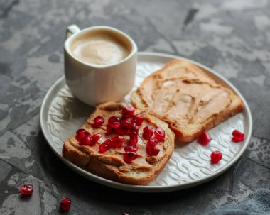 Tahtada fıstık ezmeli ve nar tohumlu lezzetli sandviçlerin yakın plan görüntüsü.