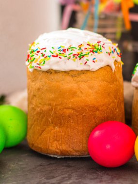 Paskalya pastalarının ve renkli yumurtaların koyu arkaplanda yakın plan görüntüsü.