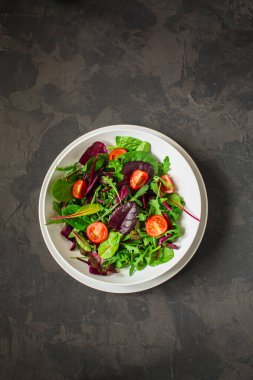 Yeşiller tabakta domateslerle karışır.