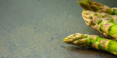 Koyu arkaplanda taze yeşil kuşkonmaz.. 