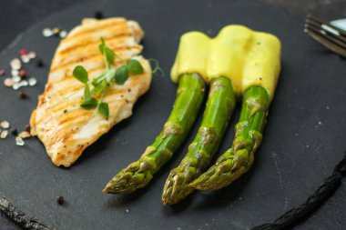 Koyu arkaplanda kuşkonmaz olan bir balık parçası.