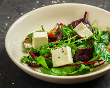 Domates ve peynirle karışık yeşiller.