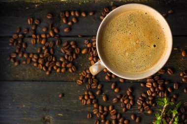 Kahve fincanını kapayın ve tahtadan arka planda tohumlar olsun.