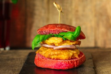 Sebzeli ve peynirli lezzetli bir burgerin yakın plan çekimi.