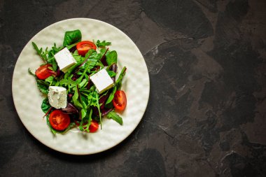 Domates ve peynirle karışık yeşiller.