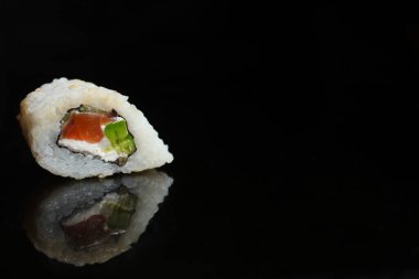 Siyah arka planda lezzetli suşi setinin yakın plan görüntüsü.