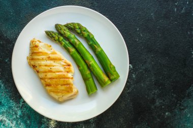 Beyaz tabakta kuşkonmaz ve ızgara somon, yakın çekim.