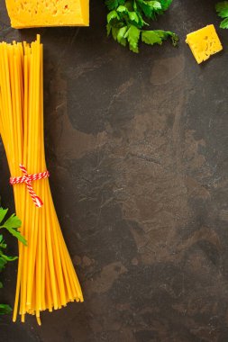 Koyu taşlı arka planda makarna malzemeleri