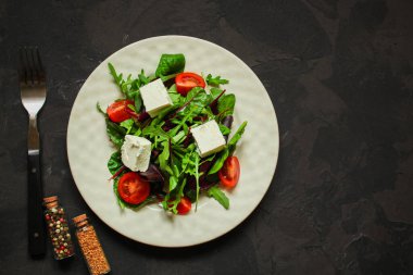 Domates ve peynirle karışık yeşiller.