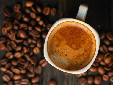 Kahve fincanını kapayın ve tahtadan arka planda tohumlar olsun.