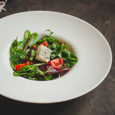 Domates ve peynirle karışık yeşiller.