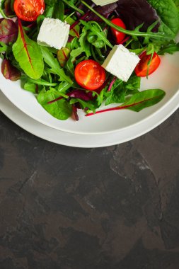 Domates ve peynirle karışık yeşiller.