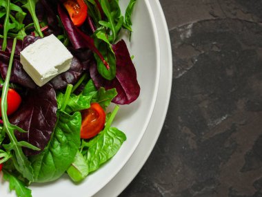 Domates ve peynirle karışık yeşiller.