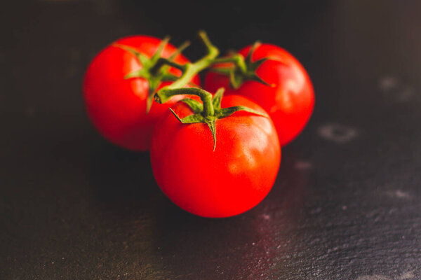 ripe cherry tomatoes on dark background