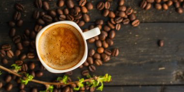 Kahve fincanını kapayın ve tahtadan arka planda tohumlar olsun.