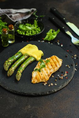 Koyu arkaplanda kuşkonmaz olan bir balık parçası.