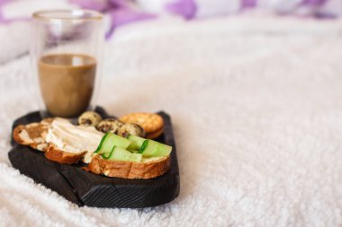 İçinde salatalık dilimleri ve bıldırcın yumurtaları olan tost.