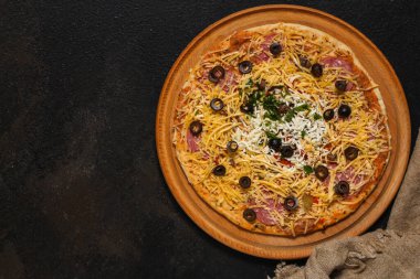 Tahta masada jambonlu, peynirli ve sebzeli pizza. 