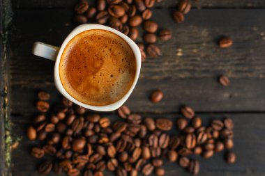 Kahve fincanını kapayın ve tahtadan arka planda tohumlar olsun.