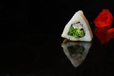 Siyah arka planda lezzetli suşi setinin yakın plan görüntüsü.