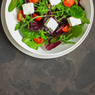 Domates ve peynirle karışık yeşiller.