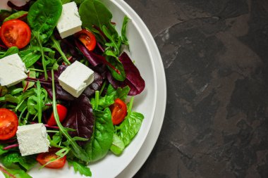 Domates ve peynirle karışık yeşiller.