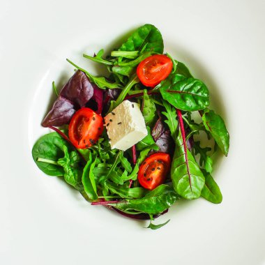 Domates ve peynirle karışık yeşiller.