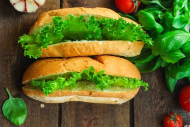 Ahşap arka planda marullu sosisli sandviçler. 