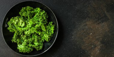 Siyah arka planda bir kasede taze yeşil salata.. 