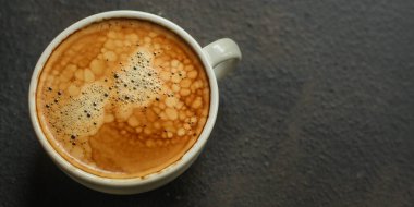 Masada köpüklü bir fincan kahve. 