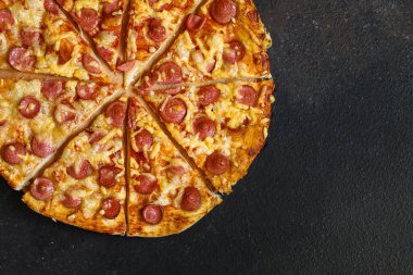 Salamlı, peynirli ve fesleğenli pizza.