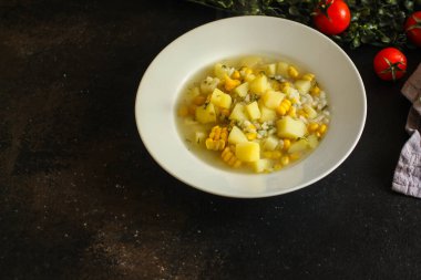 Çorbayı pirinç, mısır ve patatesle kapat.