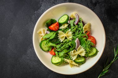 İtalyan makarna salatası farfalle, sebze, karışık yaprak konsepti. Yemek geçmişi. kopyalama alanı. Üst görünüm