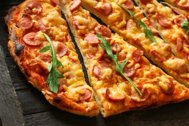 Salamlı, peynirli ve fesleğenli pizza.