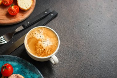 Masada köpüklü bir fincan kahve. 