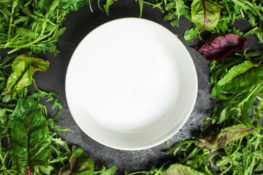 Bitkiler beyaz tabağın yanında karışıyor.