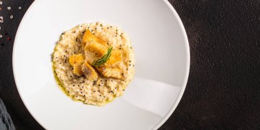 Beyaz tabakta balıklı risotto.