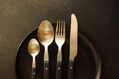 Tahta bir arka planda çatal ve bıçak.