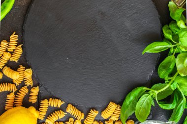 Koyu arkaplanda makarna malzemelerinin üst görünümü