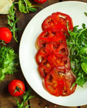 Bitkilerle dilimlenmiş domates.