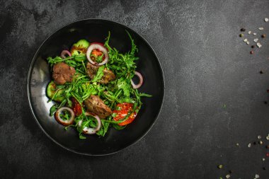 Karaciğer, soğan, domates ve otlu salata.