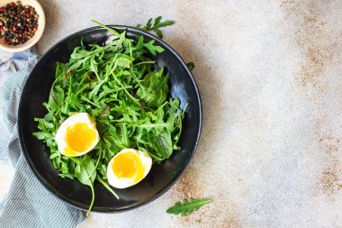 Sağlıklı salata marul yaprakları roka, pazı ve haşlanmış yumurta trend yemek fotokopi uzayı arka plan kırsalını karıştırır. Top view keto ya da paleo diyet vegan ya da vejetaryen yemekleri